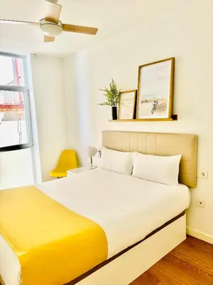 a bedroom with a large bed with a yellow blanket at LUMINOSO APARTAMENTO en el centro de Cádiz in Cádiz