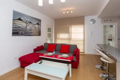 a living room with a red couch and a table at LUMINOSO APARTAMENTO en el centro de Cádiz in Cádiz