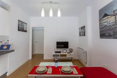a living room with a red table and a tv at LUMINOSO APARTAMENTO en el centro de Cádiz in Cádiz