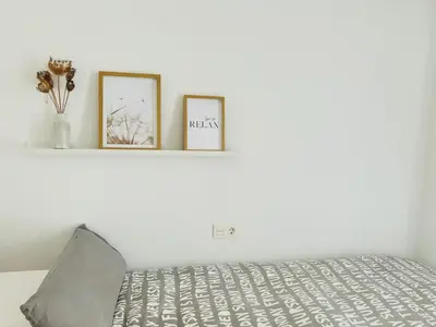 a bedroom with two picture frames on a bed at LUMINOSO APARTAMENTO en el centro de Cádiz in Cádiz