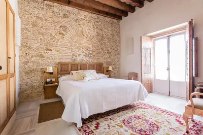 a bedroom with a bed and a brick wall at Hotel Casa de las Cuatro Torres in Cádiz