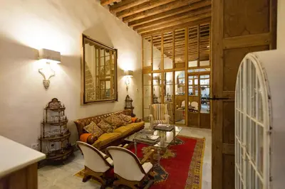 a living room with a couch and a table and chairs at Hotel Casa de las Cuatro Torres in Cádiz