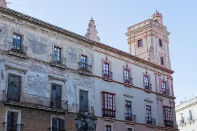 an old building with a clock tower on top of it at Hotel Casa de las Cuatro Torres in Cádiz