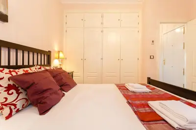 a bedroom with a large white bed with red pillows at El Atico de los INGLESES by Cadiz4Rentals in Cádiz