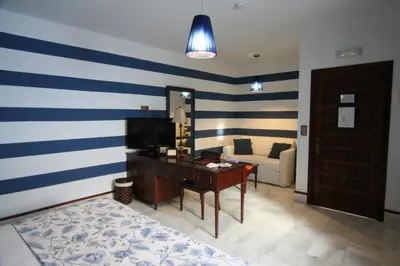 a living room with blue and white stripes on the wall at Hostal Palacio San Bartolomé in El Puerto de Santa María
