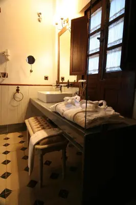 a bathroom with a sink and a mirror and a tub at Hostal Palacio San Bartolomé in El Puerto de Santa María