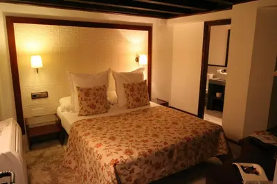 a hotel room with a large bed with pillows at Hostal Palacio San Bartolomé in El Puerto de Santa María