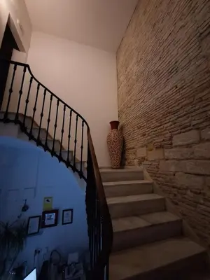 a staircase with a brick wall and a vase at Hostal Fenix in Jerez de la Frontera