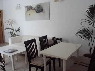 a dining room with a table and chairs and a couch at Hostal Fenix in Jerez de la Frontera