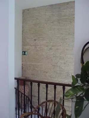 a brick wall in a room with a staircase at Hostal Fenix in Jerez de la Frontera