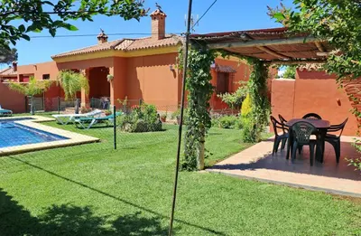 a garden with a table and chairs next to a house at Casa Maestro Roche in Roche