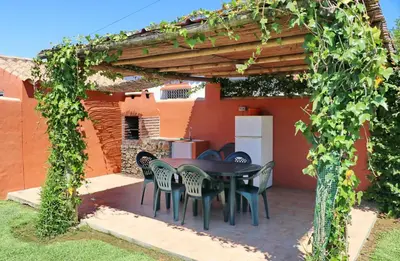 a patio with a table and chairs under a pergola at Casa Maestro Roche in Roche