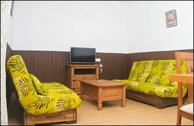 a living room with two chairs and a tv at Casa Maestro Roche in Roche