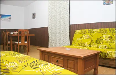 a living room with a bed and a table and a table at Casa Maestro Roche in Roche
