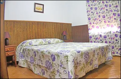a bedroom with a bed with a floral bedspread at Casa Maestro Roche in Roche