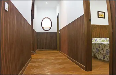 a hallway with a chair and a round mirror at Casa Maestro Roche in Roche