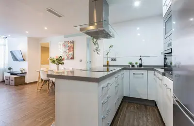 a kitchen with white cabinets and a counter top at Brisas Playa 3 Baños in Cádiz