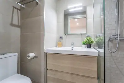 a bathroom with a sink and a toilet and a mirror at Brisas Playa 3 Baños in Cádiz