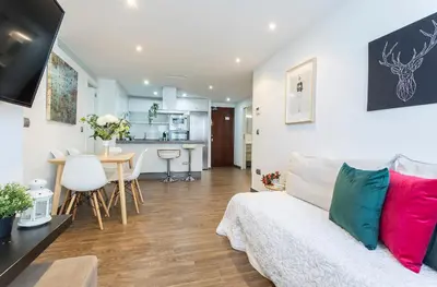 a living room with a couch and a kitchen at Brisas Playa 3 Baños in Cádiz