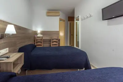 a hotel room with a bed and a couch at Hotel San Andres in Jerez de la Frontera