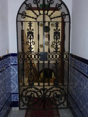 an ornate iron gate in a room with blue tiles at Hotel San Andres in Jerez de la Frontera