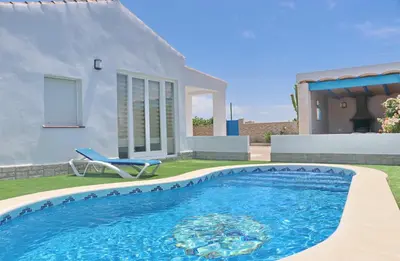 a swimming pool in front of a house at Chalet Veron in Conil de la Frontera