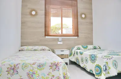 a bedroom with two beds and a window at Chalet Veron in Conil de la Frontera