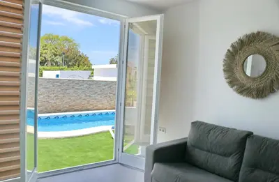 a living room with a couch and a sliding glass door at Chalet Veron in Conil de la Frontera