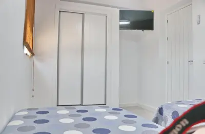 a bedroom with a white cabinet and a blue and white rug at Chalet Veron in Conil de la Frontera