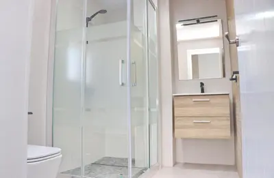 a bathroom with a glass shower stall and a toilet at Chalet Veron in Conil de la Frontera