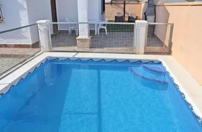 a blue swimming pool with a fence around it at Chalet Peñuelas in Conil de la Frontera
