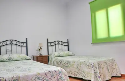 a bedroom with two beds and a window at Chalet Peñuelas in Conil de la Frontera
