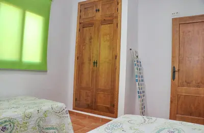 a room with a wooden door and a bed in it at Chalet Peñuelas in Conil de la Frontera