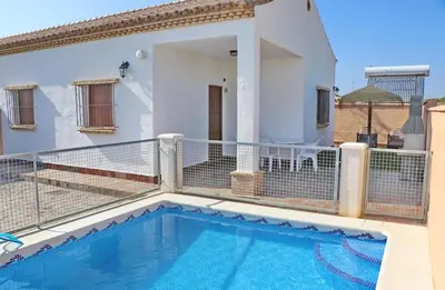 a house with a swimming pool on a balcony at Chalet Peñuelas in Conil de la Frontera