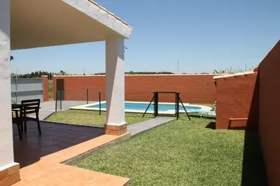 a backyard with a swing set and a pool at Chalet Cala de Roche in Roche