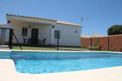 a swimming pool in front of a house at Chalet Cala de Roche in Roche
