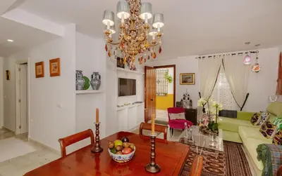 a living room with a table and a chandelier at Rota playa Calle Puyana in Rota