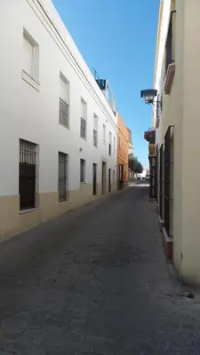 an empty street next to a white building at Rota playa Calle Puyana in Rota