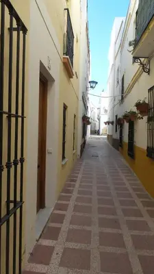 an empty alley in an old town with buildings at Rota playa Calle Puyana in Rota