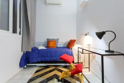 a bedroom with a bed and a red chair at La PEPA1812 by Cadiz4Rentals in Cádiz