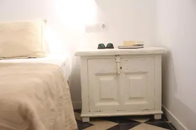 a bedroom with a bed and a white cabinet with shoes on it at La PEPA1812 by Cadiz4Rentals in Cádiz