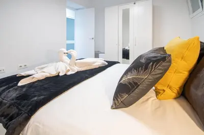a bedroom with a bed with two swans on it at Apartamento Arco de los Blanco in Cádiz