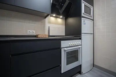 a kitchen with a stove and a refrigerator at Apartamento Arco de los Blanco in Cádiz