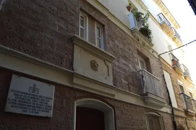 a brick building with a window and a balcony at Apartamento Arco de los Blanco in Cádiz