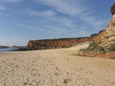 a sandy beach with rocks in the background at Alojamientos Rurales Inma in Conil de la Frontera