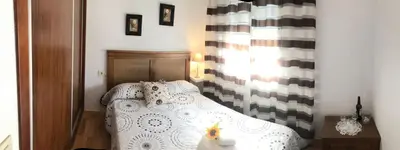 a small bedroom with a white bed and a window at Alojamientos Rurales Inma in Conil de la Frontera