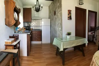 a kitchen with a table and a white refrigerator at Alojamientos Rurales Inma in Conil de la Frontera