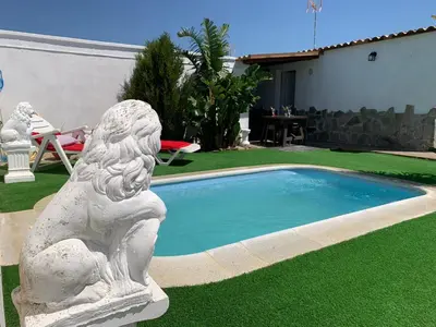 a statue sitting next to a small swimming pool at Alojamientos Rurales Inma in Conil de la Frontera