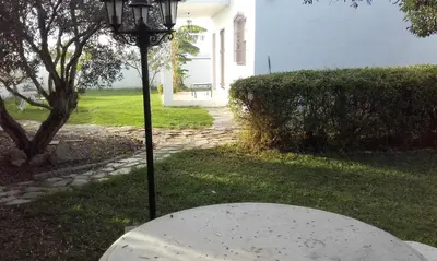 a table in a yard with a lamp in the grass at Alojamientos Rurales Inma in Conil de la Frontera