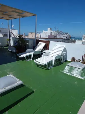 three lounge chairs sitting on top of a roof at Hostal Gran Capitan in Chipiona